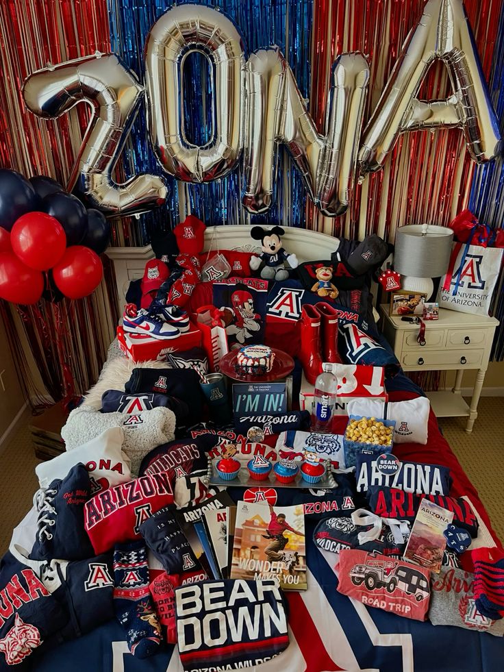 University of Arizona bed party with 2024 balloon letters, red and blue streamers, and Bear Down merchandise