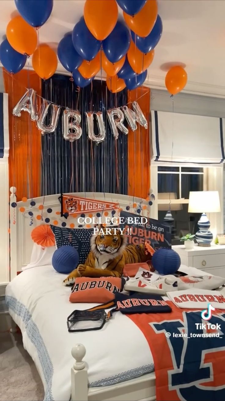 Auburn bed party with AUBURN balloon letters, orange and blue balloons, and Tigers merchandise