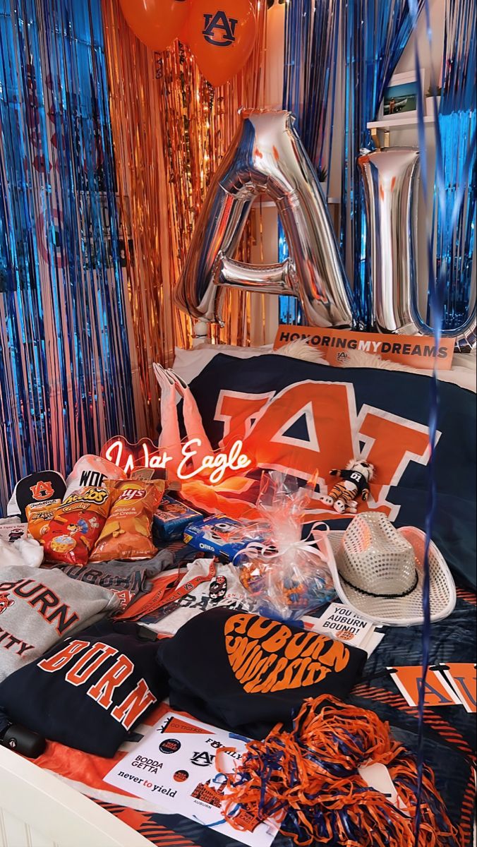 Auburn bed party with large AU balloon letters, blue and orange streamers, War Eagle merchandise and Auburn decorations