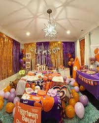 Clemson bed party with purple and orange decorations, balloons, and Tigers merchandise collection