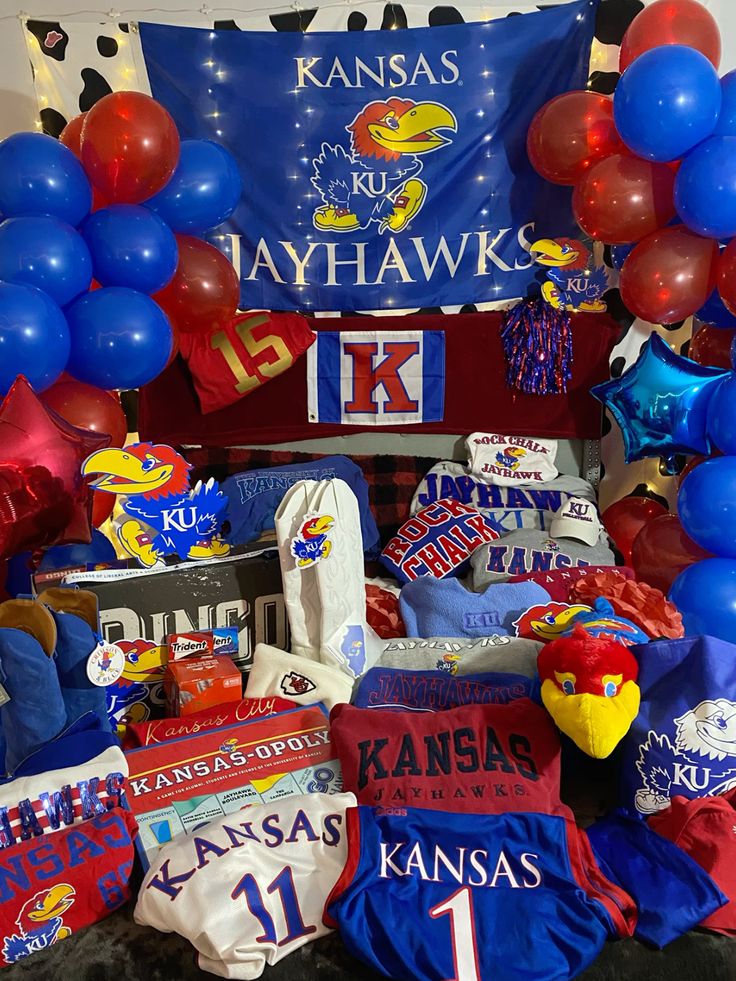 University of Kansas bed party with Kansas Jayhawks banner, red and blue balloons, and extensive KU merchandise collection
