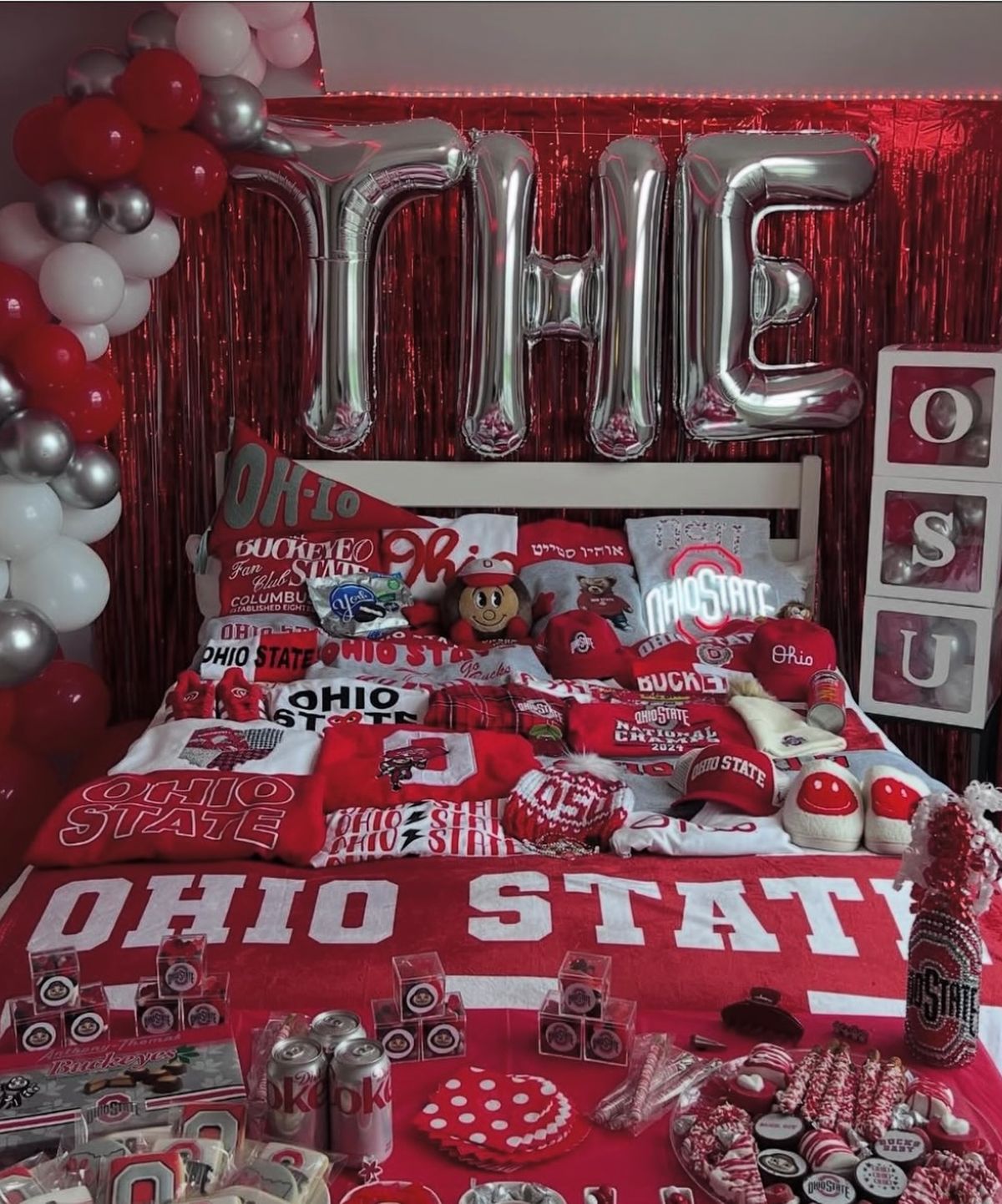Ohio State bed party with THE balloon letters, red streamers, and extensive Buckeyes merchandise