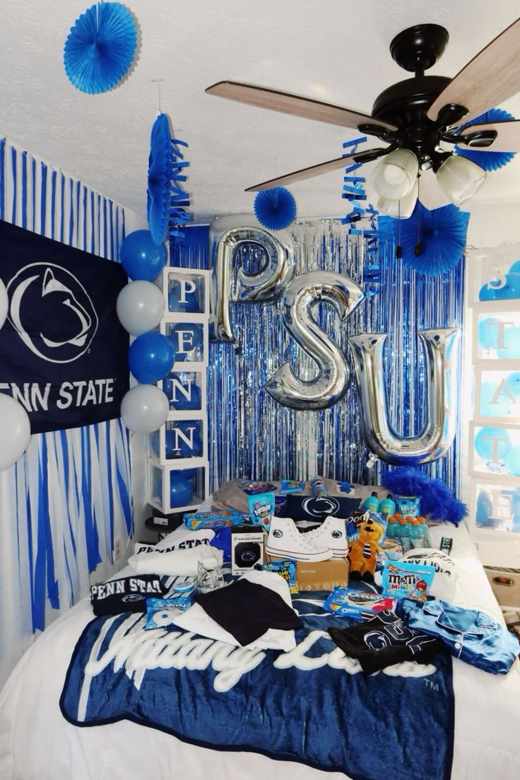 Penn State bed party with PSU balloon letters, blue streamers, and extensive Nittany Lions merchandise and decorations