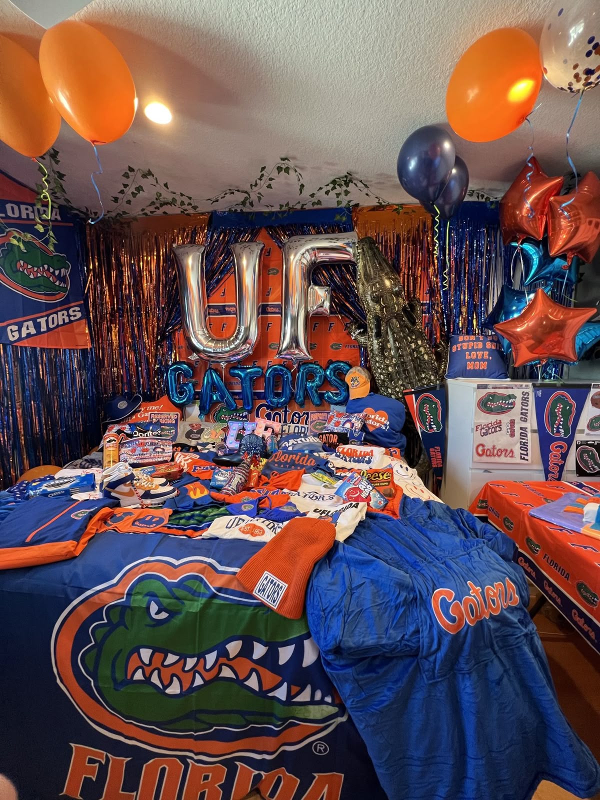 Florida Gators bed party with UF letters, GATORS balloons, and massive collection of Florida merchandise